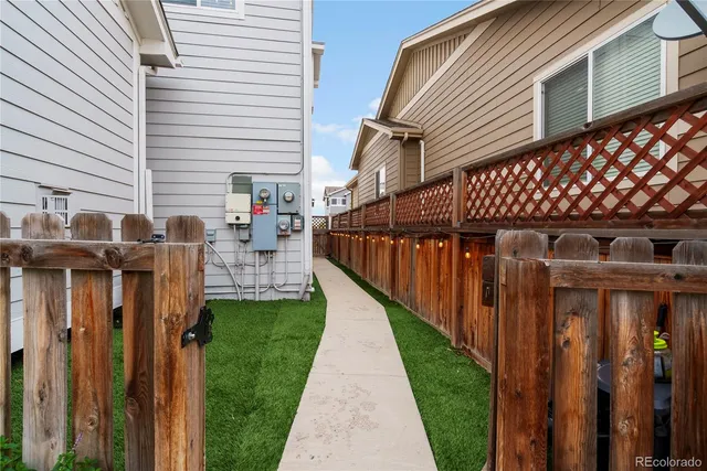 a view of a pathway of a house with wooden fence