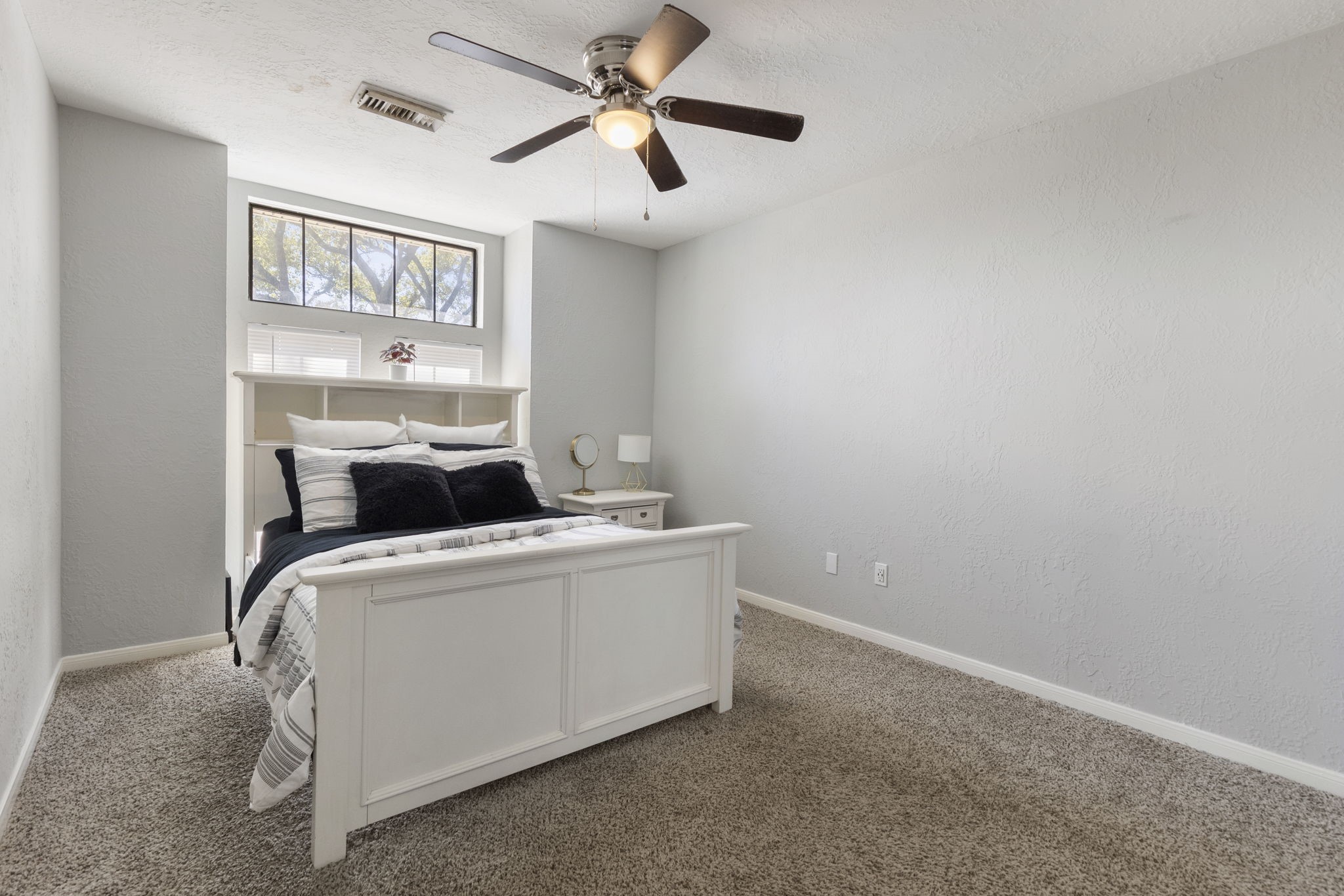 2110 Paso Rello Drive Houston, TX 77077 - Photo 35 of 41 This secondary bedroom features a cozy space with neutral walls and carpeted flooring, complemented by a ceiling fan and a large window for natural light.