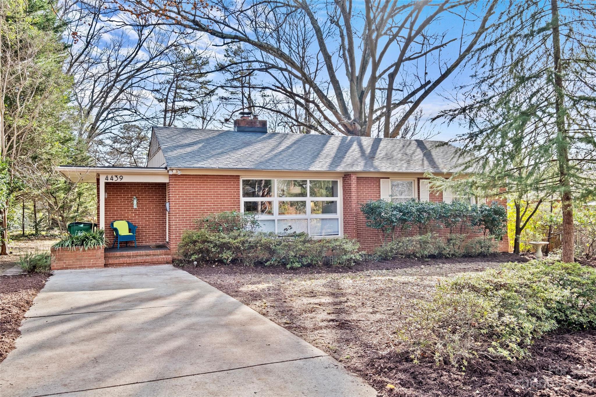 a front view of a house with a yard and potted plants