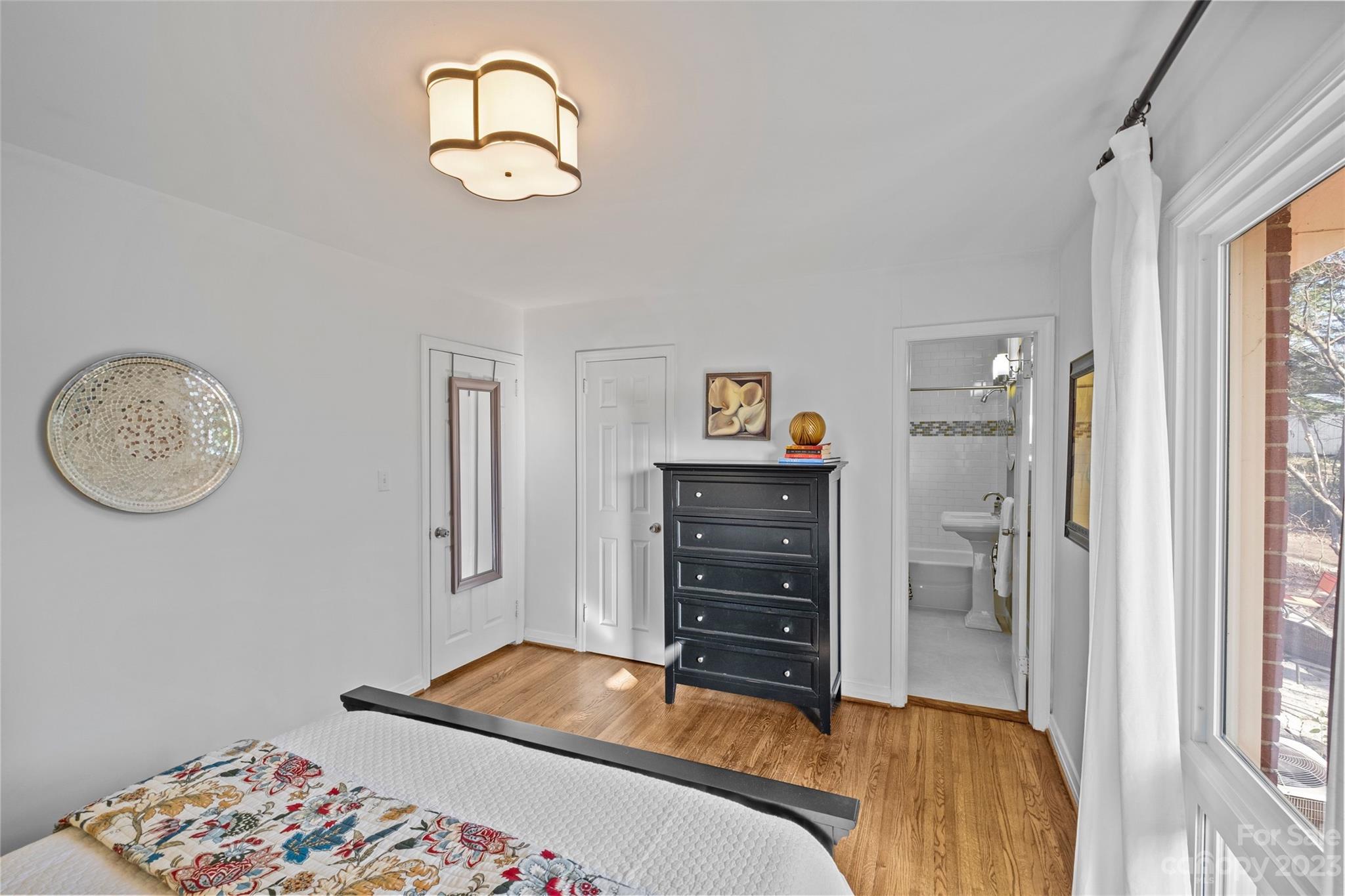 4439 Applegate Road Charlotte, NC 28209 - Photo 28 of 34 a bedroom with a bed and a chandelier