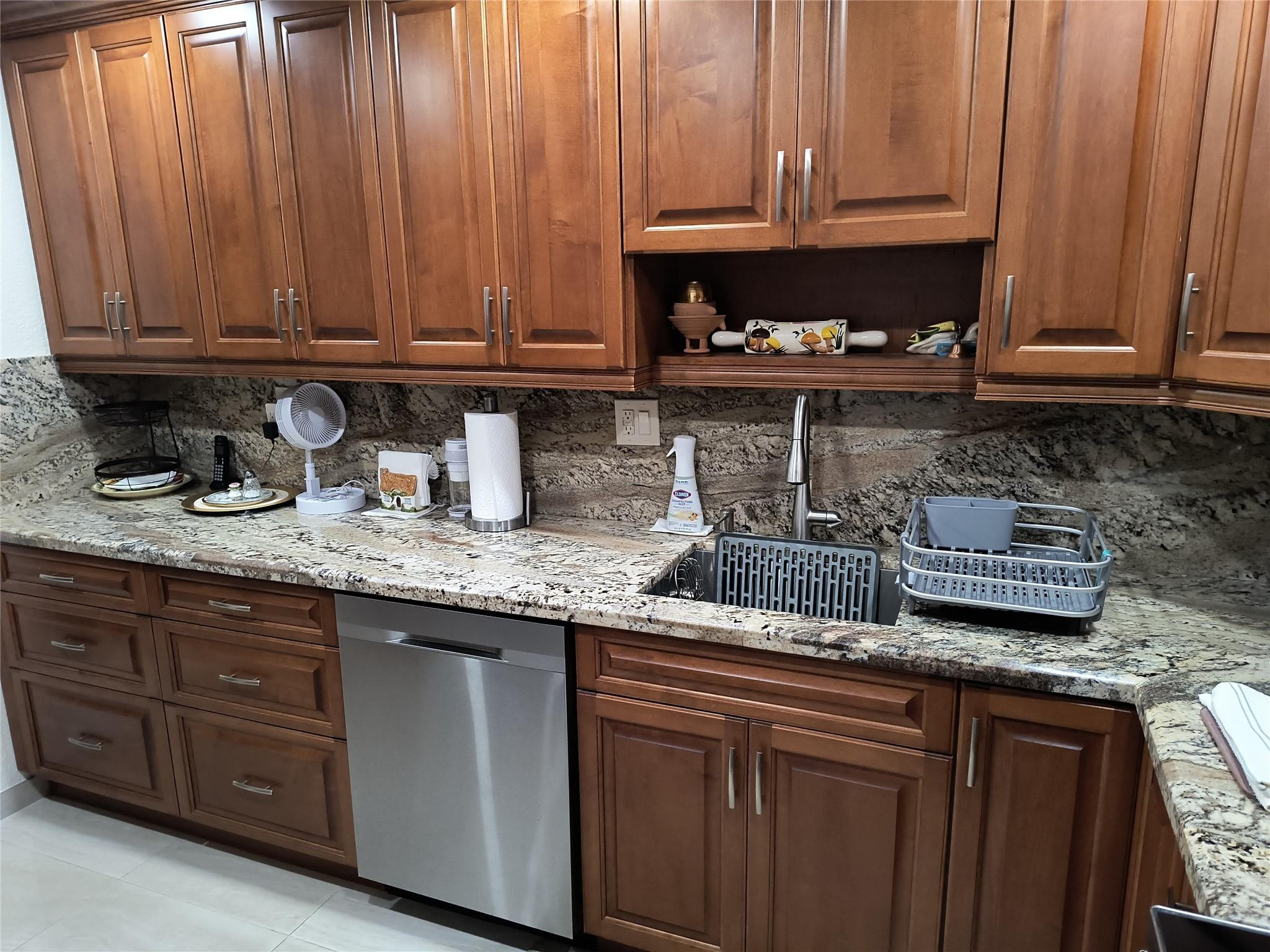 10777 West Sample Road, Unit 402 Coral Springs, FL 33065 - Photo 17 of 27 a kitchen with granite countertop stainless steel appliances granite countertop a sink a stove and a microwave