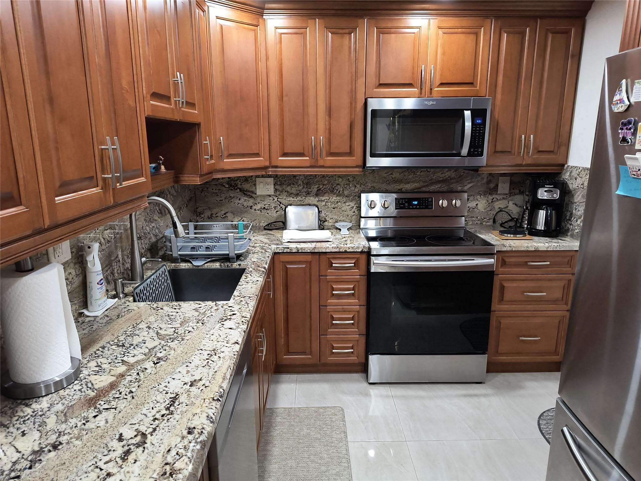 10777 West Sample Road, Unit 402 Coral Springs, FL 33065 - Photo 19 of 27 a kitchen with a stove and a microwave