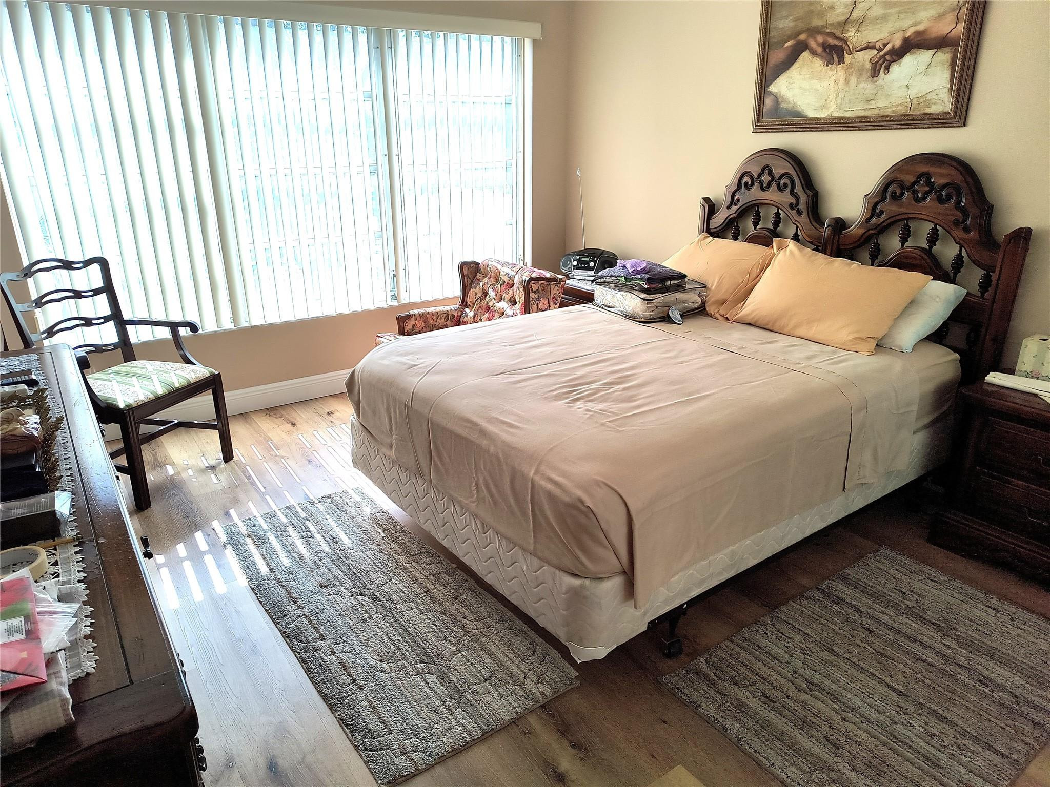 10777 West Sample Road, Unit 402 Coral Springs, FL 33065 - Photo 20 of 27 a bedroom with a bed and wooden floor