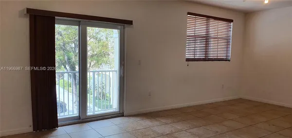 an empty room with wooden floor and a window