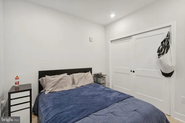 a bedroom with a bed and a white wall painting