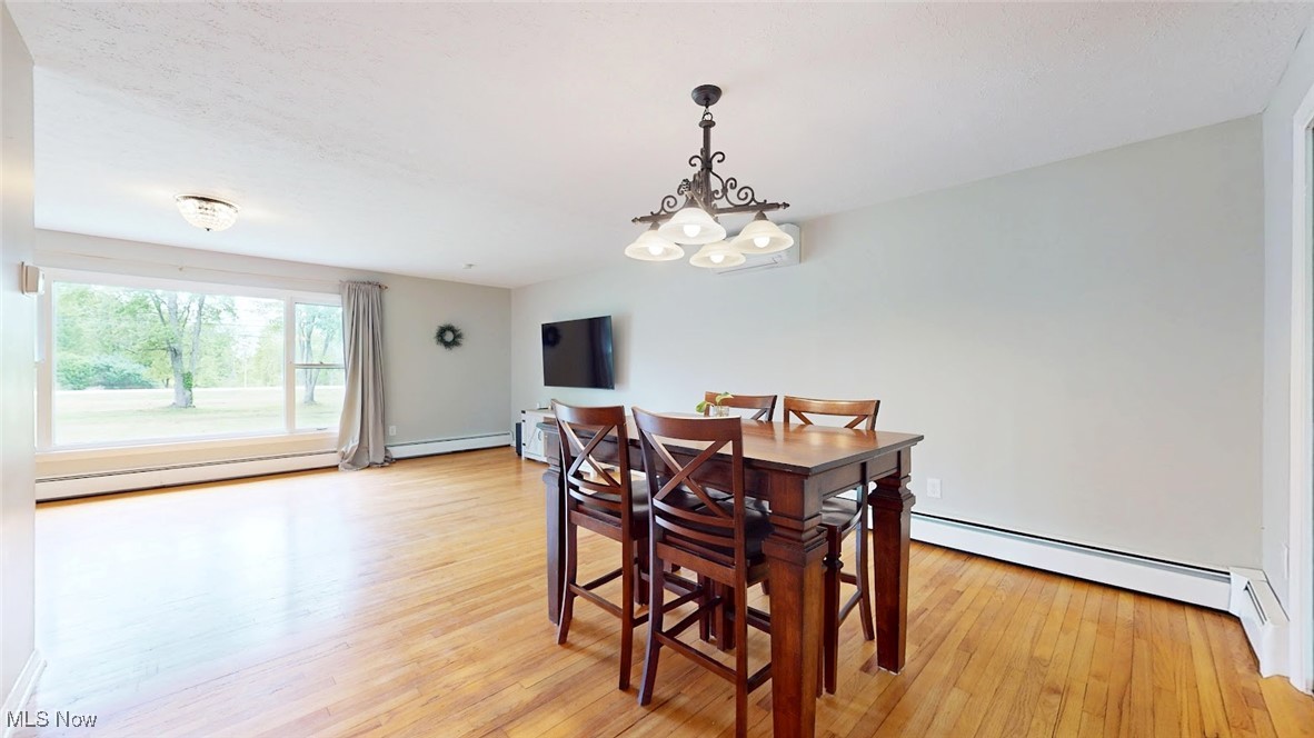 1412 Bell Road Chagrin Falls, OH 44022 - Photo 13 of 43 Dining room featuring a baseboard radiator, light wood-style floors, and a chandelier