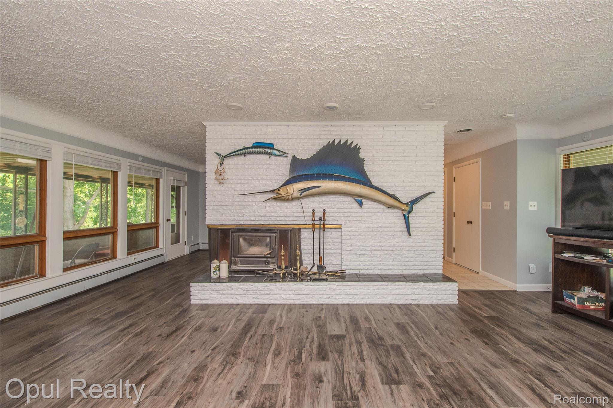 6455 Norham Road Bloomfield Hills, MI 48301 - Photo 45 of 93 Living area featuring wood-finish flooring and a white brick fireplace with a wood-burning insert
