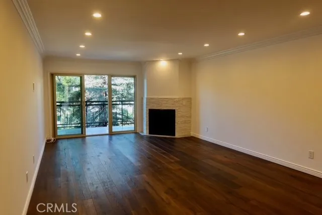 a view of empty room with wooden floor and fireplace