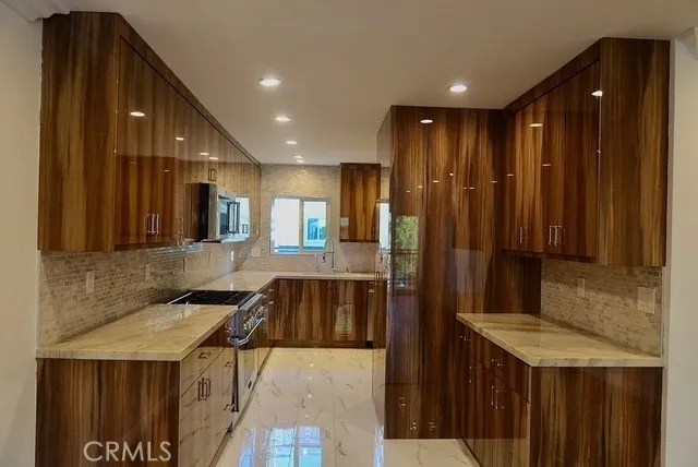 a kitchen with kitchen island granite countertop wooden cabinets a sink and a stove