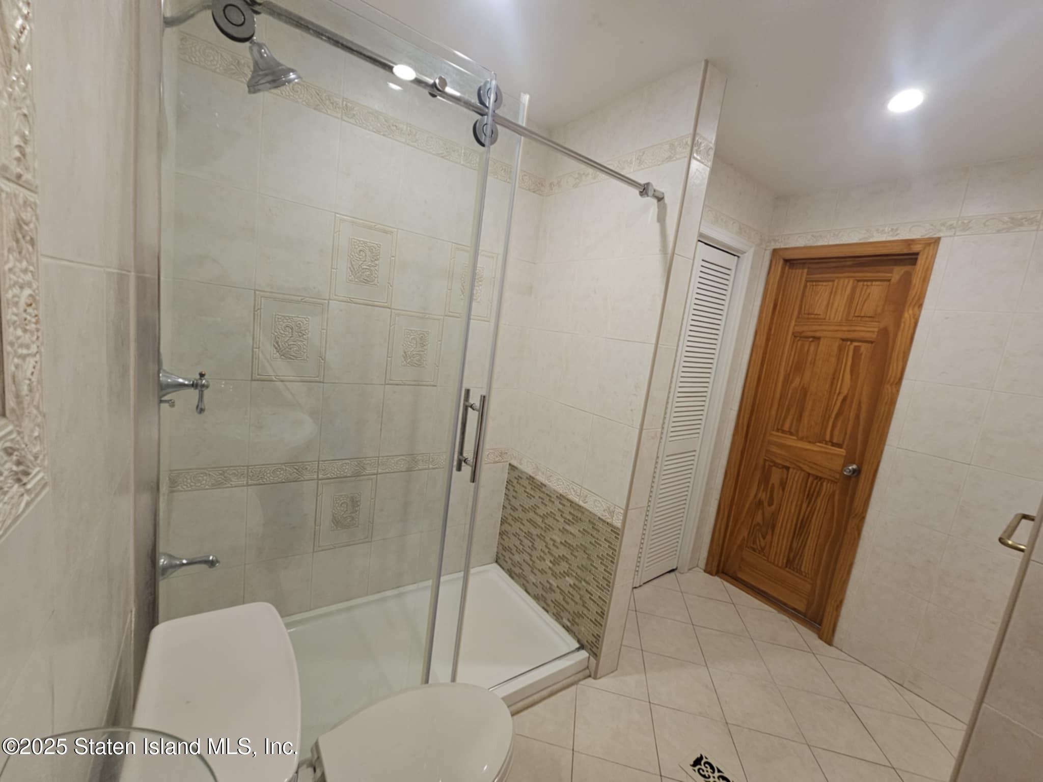 58 Selvin Loop Staten Island, NY 10303 - Photo 15 of 19 a bathroom with a shower and a toilet