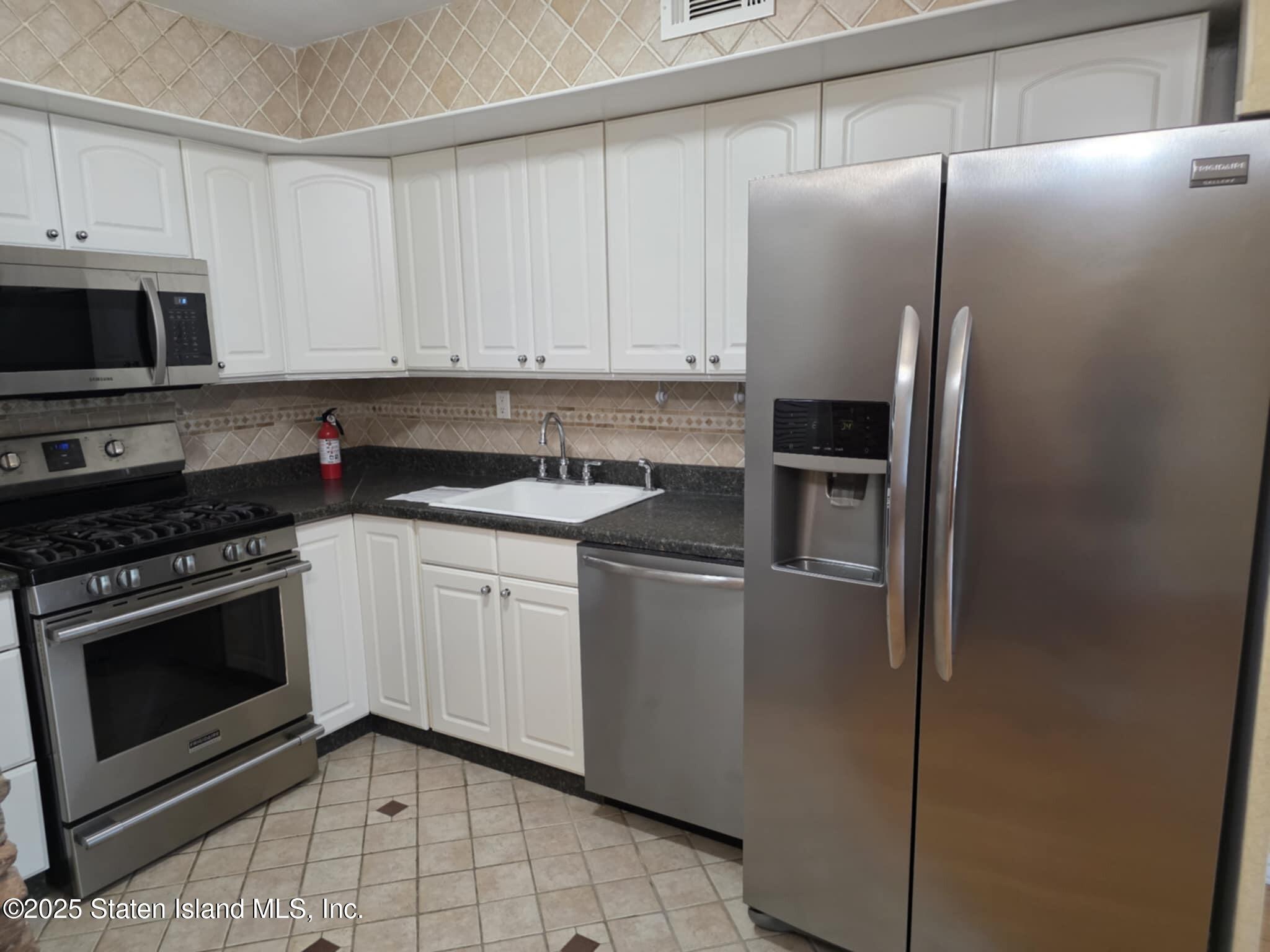 58 Selvin Loop Staten Island, NY 10303 - Photo 9 of 19 a kitchen with a sink stove and refrigerator