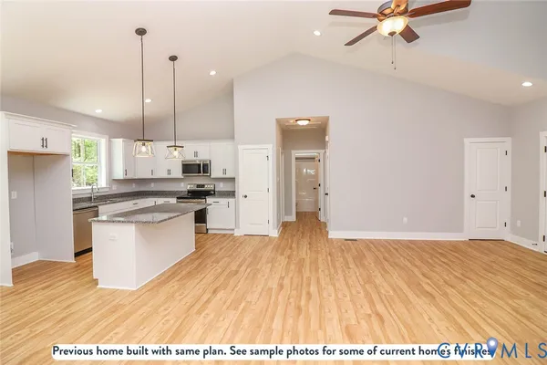 a kitchen with granite countertop a stove a sink and a refrigerator