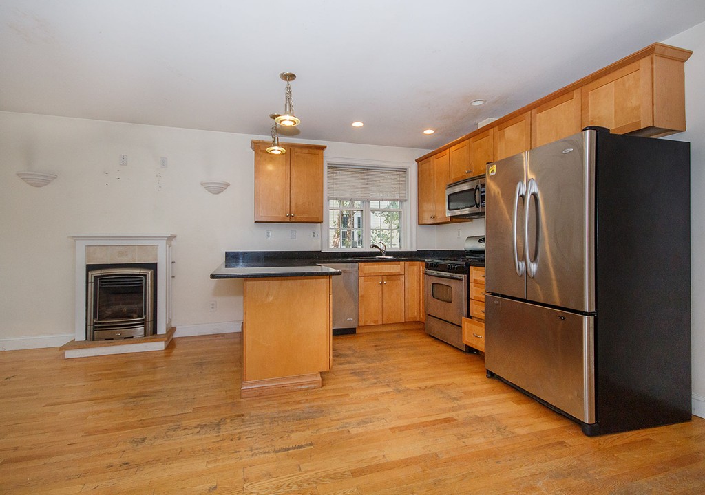 a kitchen with granite countertop stainless steel appliances a refrigerator a stove top oven and a sink