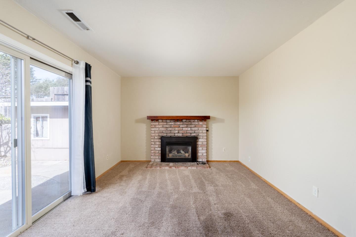 301 Park Circle Marina, CA 93933 - Photo 4 of 18 an empty room with a fireplace and window