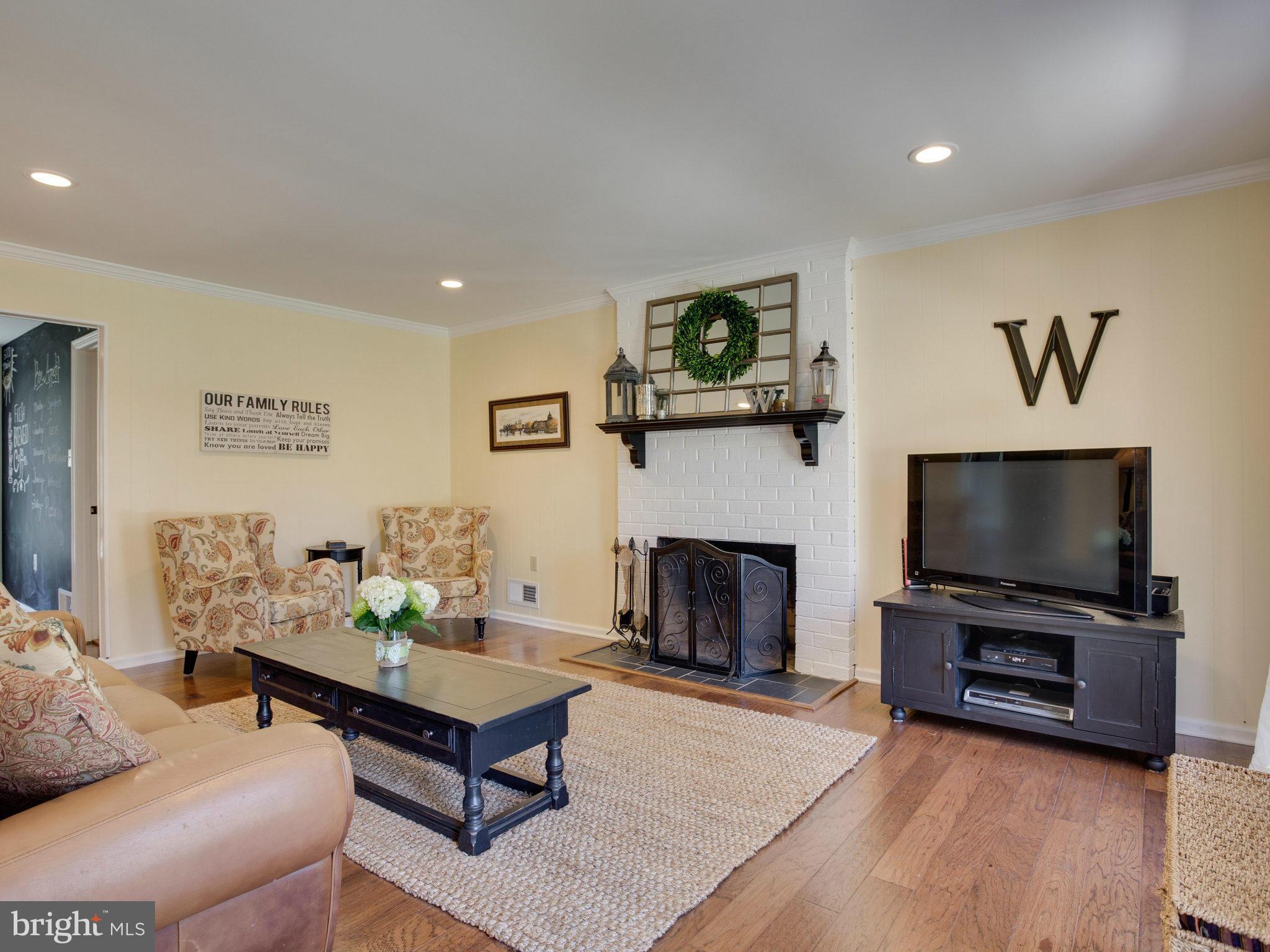 8231 Crown Court Road Alexandria, VA 22308 - Photo 3 of 30 a living room with furniture a flat screen tv and a fireplace