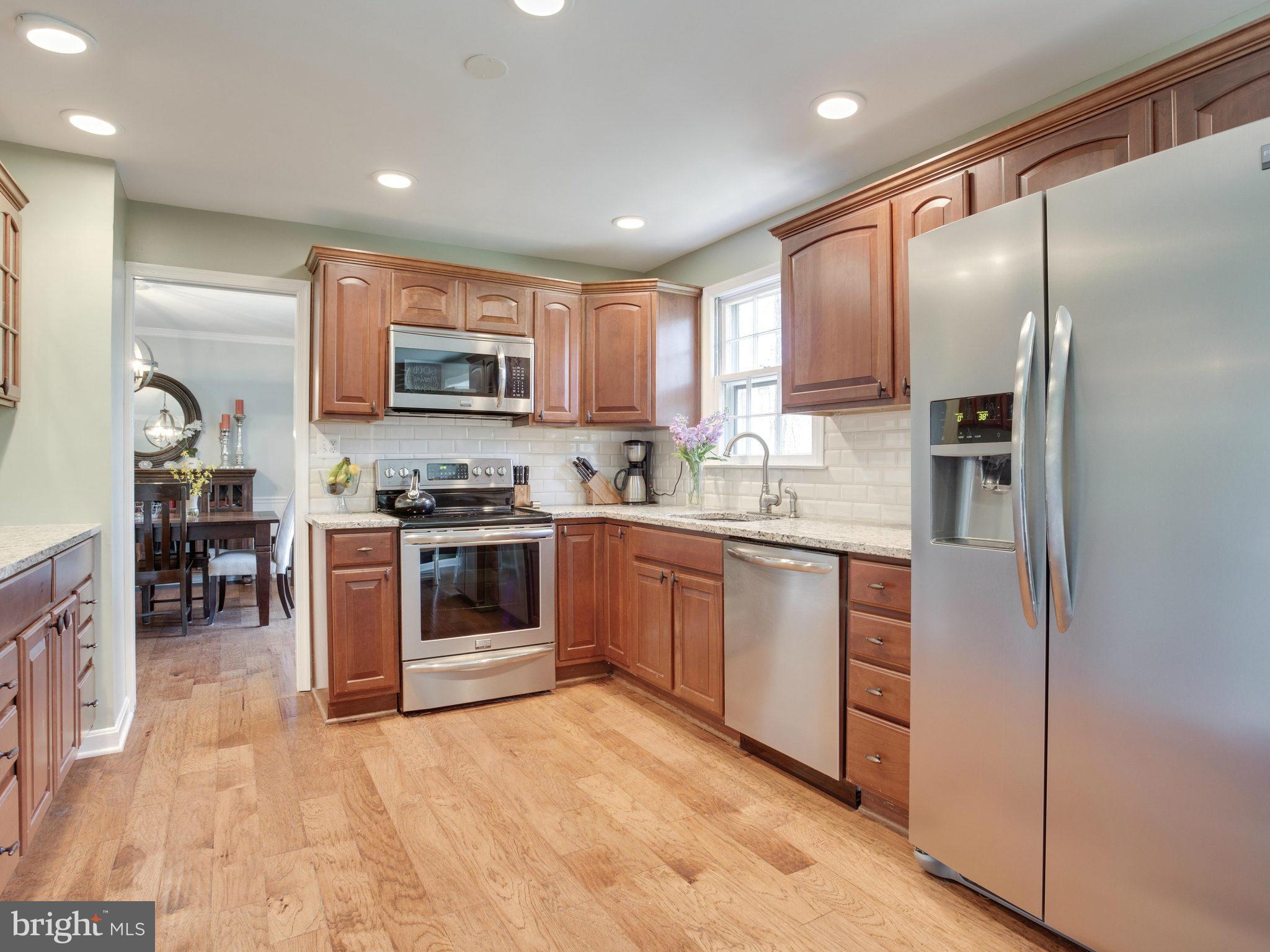 8231 Crown Court Road Alexandria, VA 22308 - Photo 7 of 30 a kitchen with stainless steel appliances granite countertop a stove top oven a sink and a refrigerator