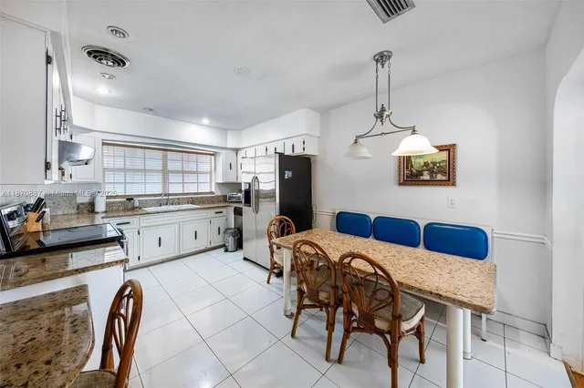 a kitchen with a table chairs and refrigerator