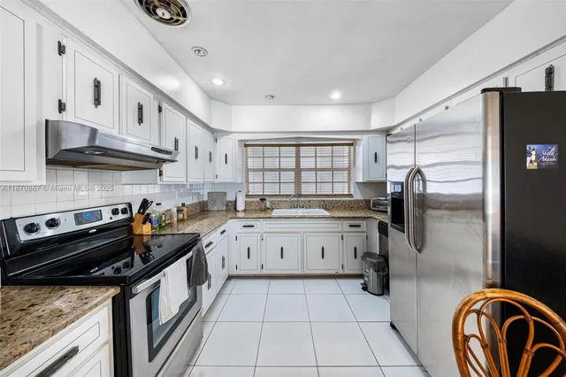 a kitchen with a stove sink and cabinets