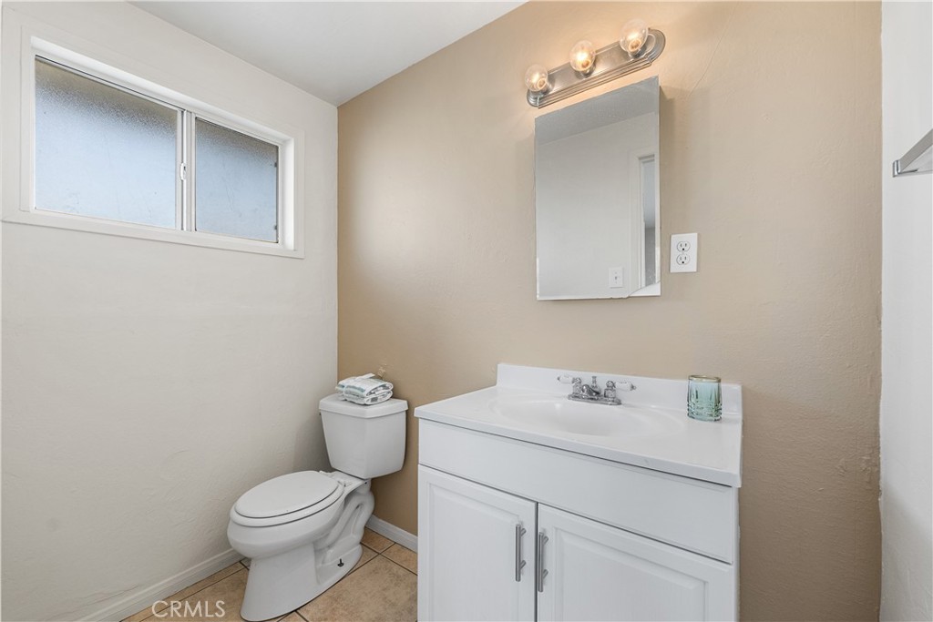 1252 East Ave R 6 Palmdale, CA 93550 - Photo 25 of 40 a bathroom with a toilet sink vanity and mirror