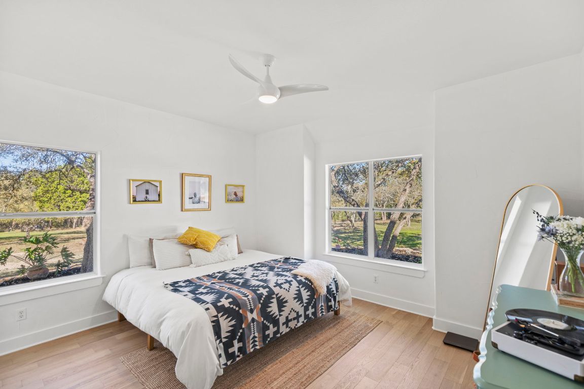 7197 Mt Sharp Road Wimberley, TX 78676 - Photo 27 of 39 a bedroom with a large bed and a window