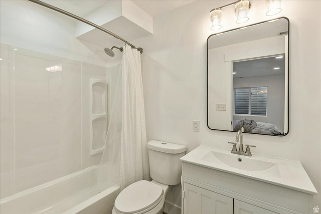 3916 South Sage Wood Avenue Mapleton, UT 84664 - Photo 25 of 33 Bathroom featuring a white vanity with integrated sink, brushed nickel faucet, a rectangular framed mirror, and a full-size bathtub with an overhead shower and built-in shelving