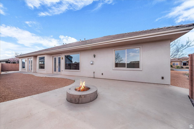 691 Rainier Drive St. George, UT 84770 - Photo 18 of 24 Rear view of house featuring a patio area, stucco siding, an outdoor fire pit, and french doors