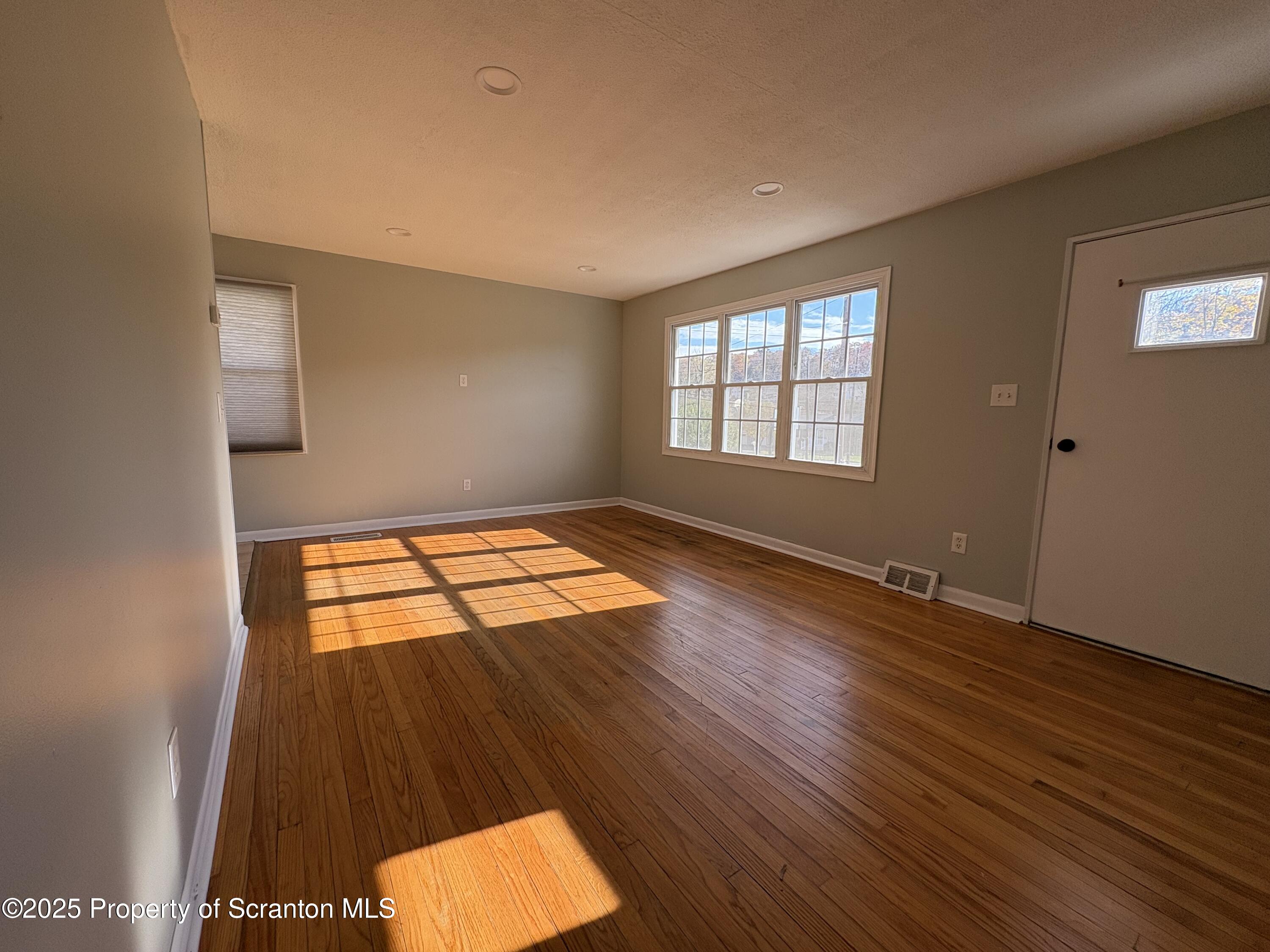 812 Old Winola Road Clarks Summit, PA 18411 - Photo 14 of 25 an empty room with wooden floor and windows