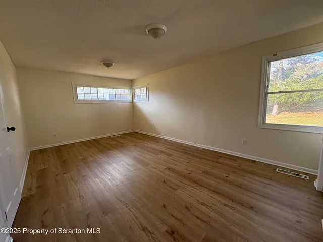 a view of room with window and wooden floor