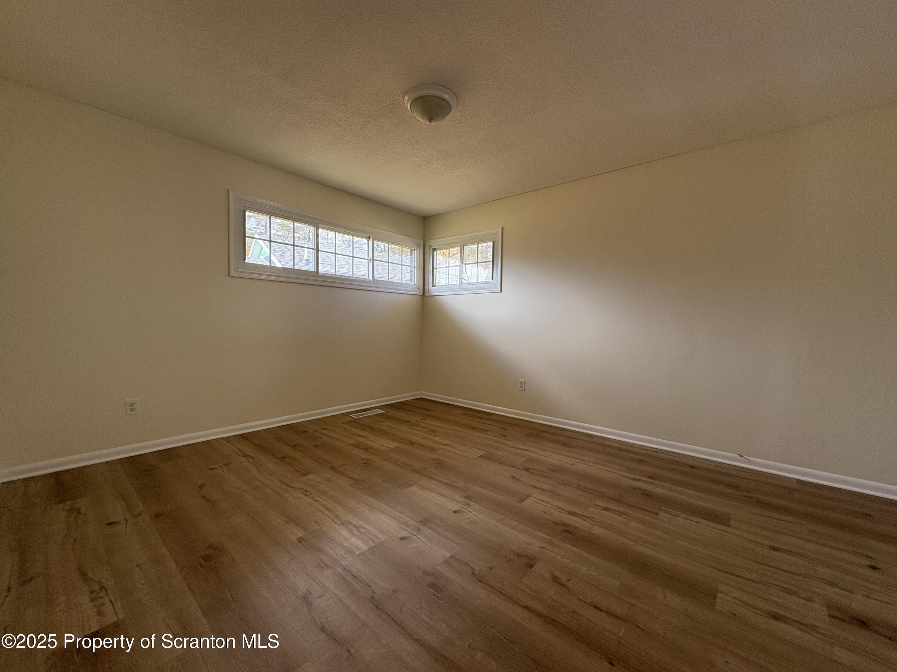 812 Old Winola Road Clarks Summit, PA 18411 - Photo 23 of 25 an empty room with wooden floor and windows