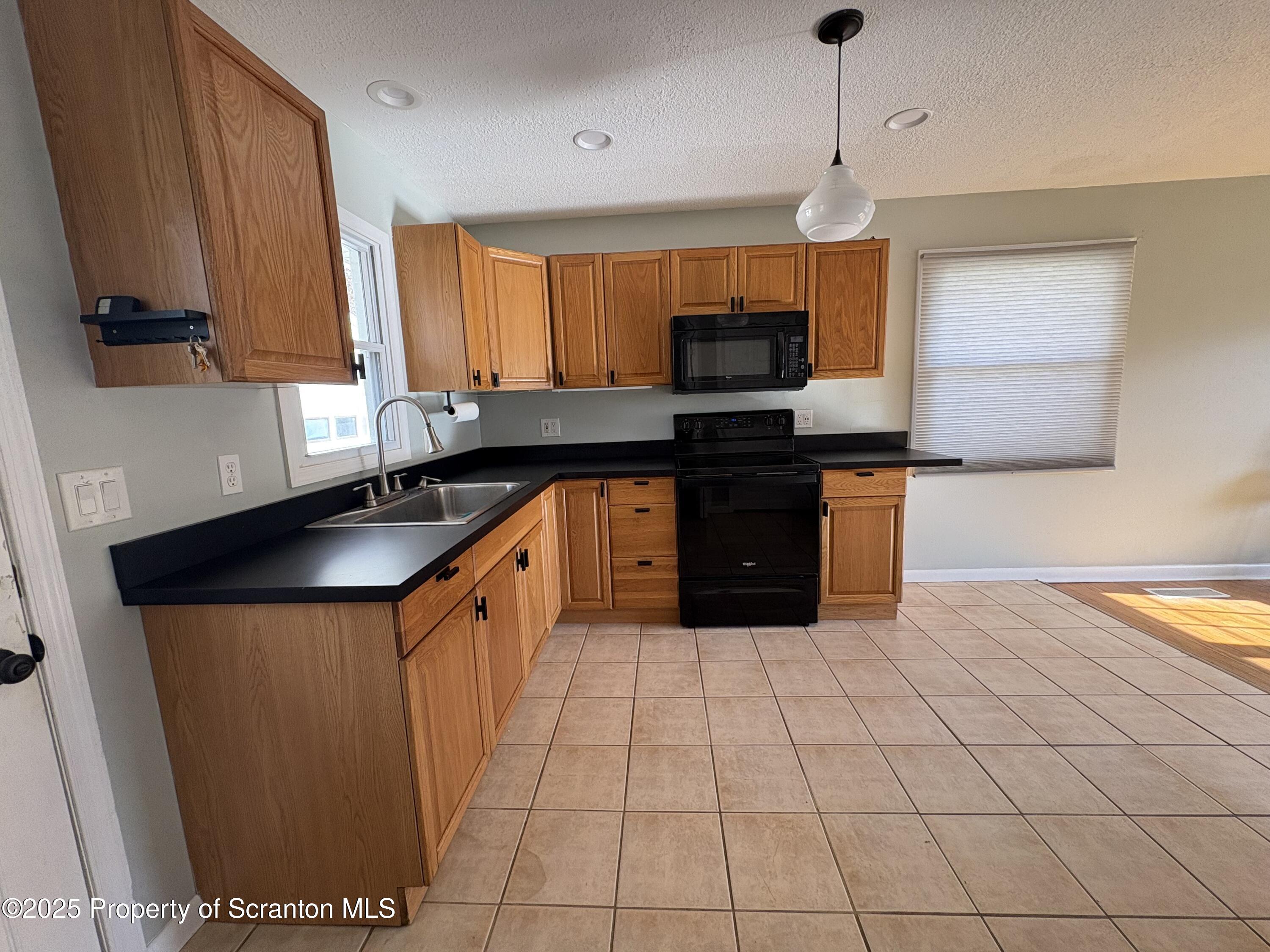 812 Old Winola Road Clarks Summit, PA 18411 - Photo 8 of 25 a kitchen with stainless steel appliances granite countertop a sink counter space cabinets and a window
