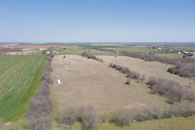 a view of a dry yard with wooden fence