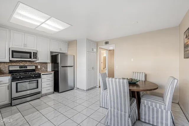 a kitchen with stainless steel appliances a refrigerator and a stove top oven