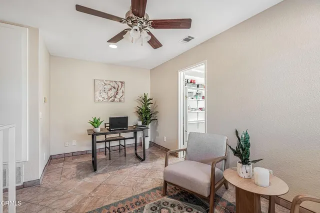 a living room with furniture a chandelier and a potted plant