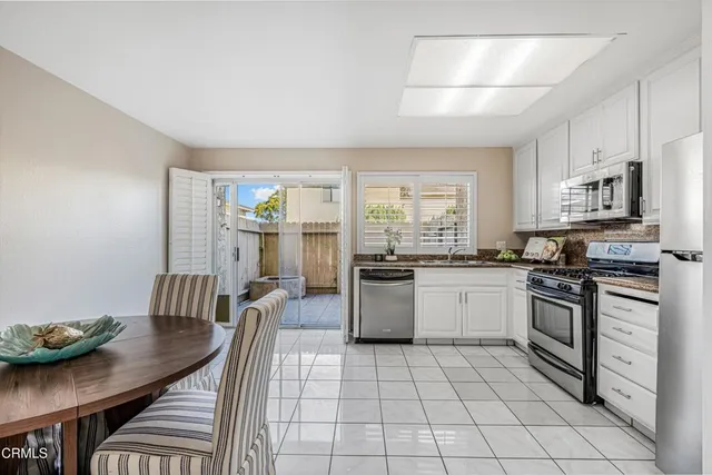 a kitchen with stainless steel appliances granite countertop a stove a sink dishwasher and a refrigerator