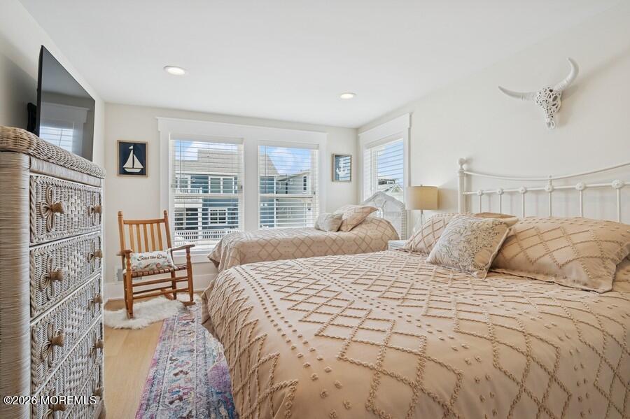 124 2nd Avenue Manasquan, NJ 08736 - Photo 21 of 38 a large bedroom with a large bed a flat tv screen and balcony