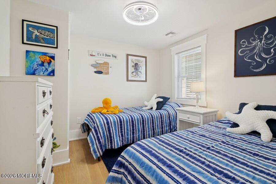 124 2nd Avenue Manasquan, NJ 08736 - Photo 24 of 38 a bedroom with two beds and a dresser next to a window