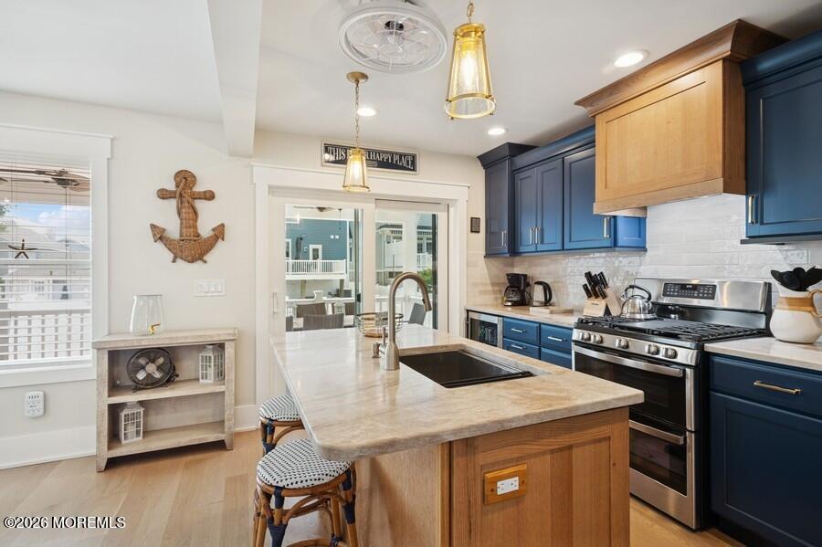 124 2nd Avenue Manasquan, NJ 08736 - Photo 7 of 38 a kitchen with a stove a sink a dining table and chairs with wooden floor