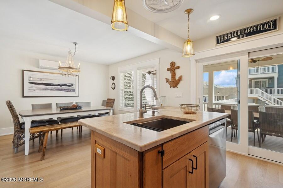 124 2nd Avenue Manasquan, NJ 08736 - Photo 8 of 38 a kitchen with kitchen island granite countertop a stove a sink a dining table and chairs with wooden floor