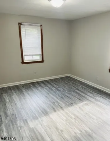 a view of an empty room and wooden floor