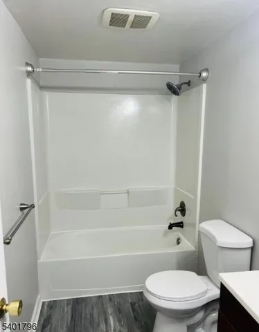 a white toilet sitting next to a bath tub