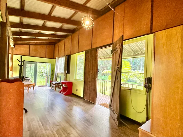 a view of an empty room with wooden floor and windows