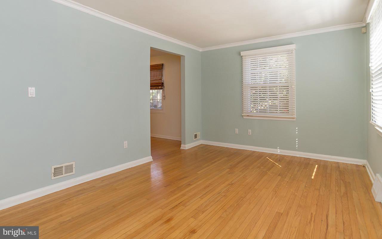 708 Sudbrook Road Pikesville, MD 21208 - Photo 15 of 30 an empty room with wooden floor and windows