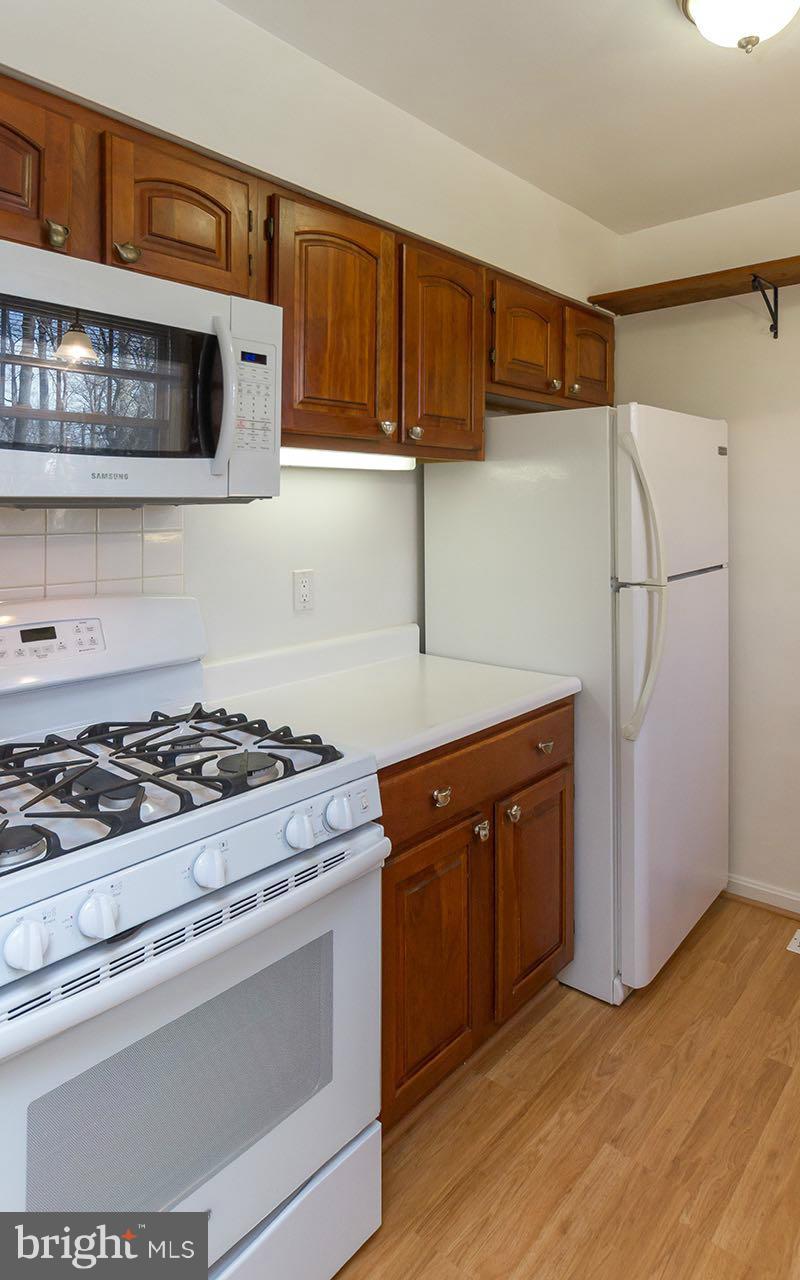 708 Sudbrook Road Pikesville, MD 21208 - Photo 6 of 30 a kitchen with stainless steel appliances granite countertop a stove a refrigerator and a microwave