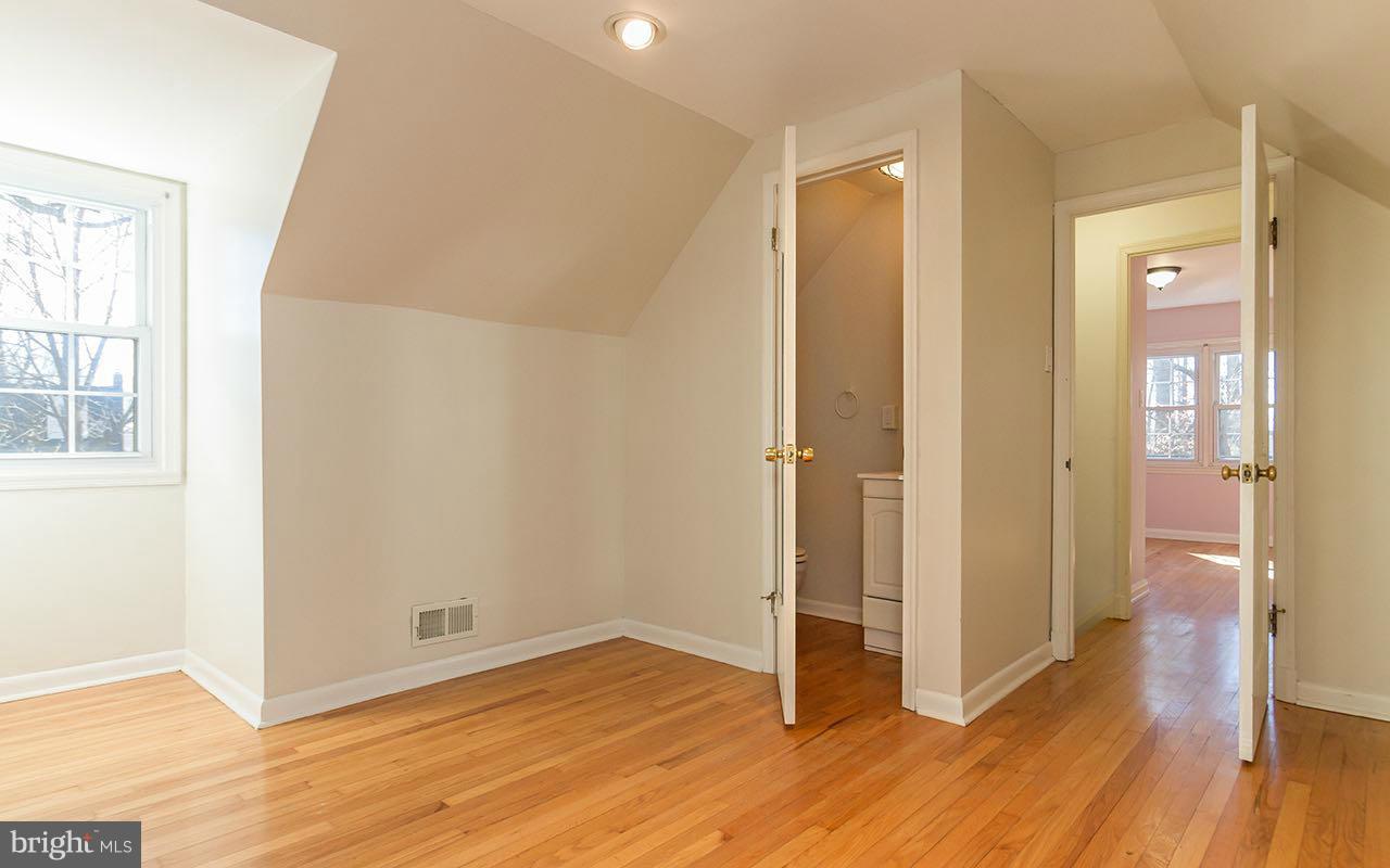 708 Sudbrook Road Pikesville, MD 21208 - Photo 7 of 30 an empty room with wooden floor and windows