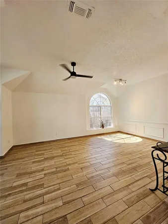 a view of a room with wooden floor and fan