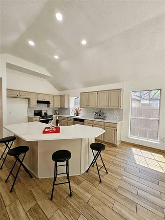 a room with stainless steel appliances kitchen island a table and chairs in it