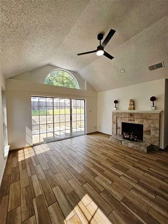 wooden floor fireplace and windows in an empty room