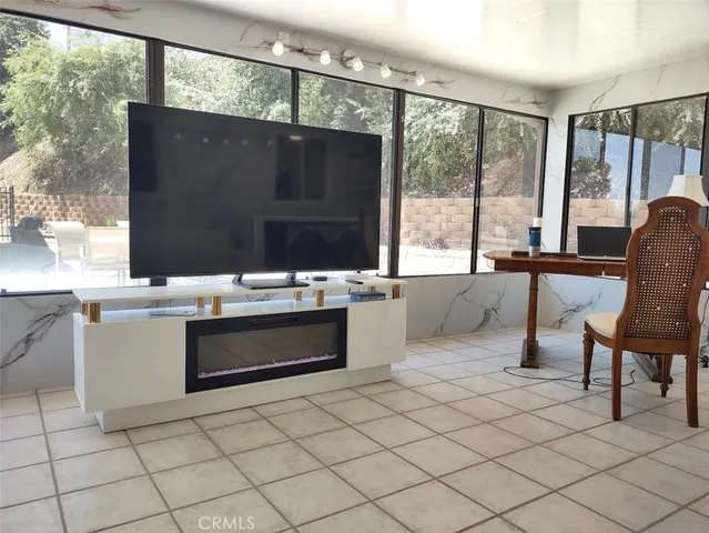 a living room with stainless steel appliances kitchen island granite countertop furniture a large window and a sink