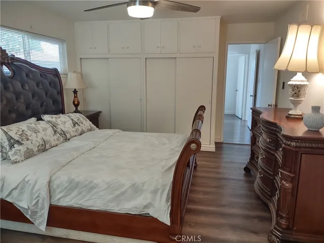 a bedroom with bed and wooden floor