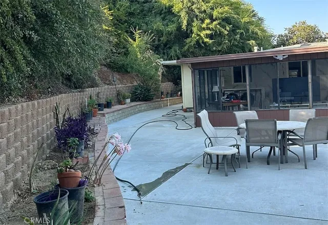a view of a patio with table and chairs and potted plants